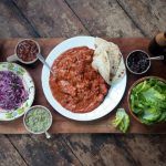 butter chicken curry recipe with naan bread and salad on the side