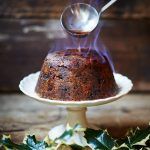 Christmas pudding flaming blue with holly as decoration