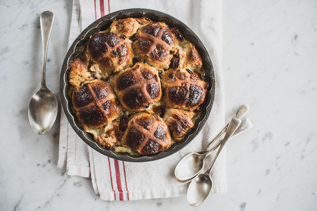 homemade hot cross buns in a dish being used up