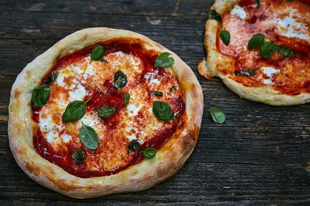 how to make the perfect pizza topping - 2 pizzas with basil, mozarella and tomato on top