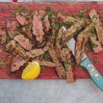 Healthy steak cooked medium rare and sliced on a board with lemon