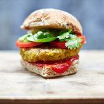 vegan burger with ketchup, tomatoes and coriander in a burger