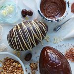chocolate eggs being decorates with white drizzle and crunchy nut