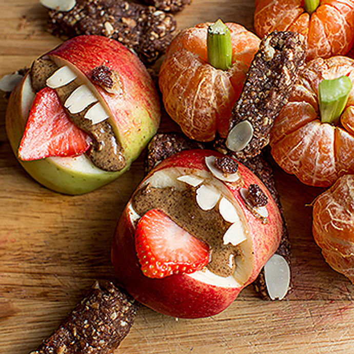 Healthy Halloween treats with apples and strawberries looking like monsters