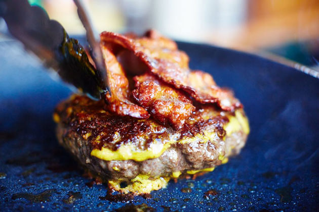 ultimate burger recipe with mustard beef burger and bacon on top