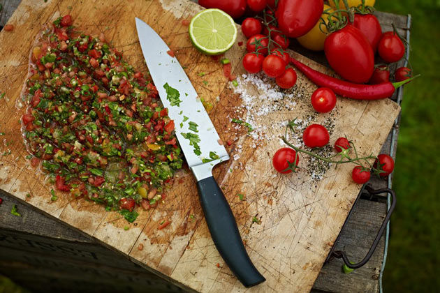kitchen chopping board with fresh herbs and tomatoes and chilli