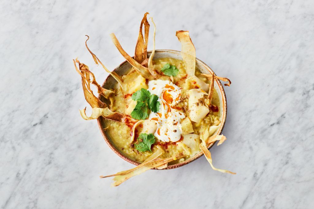 Bowl of parsnip soup with coriander and parsnip crisps on top