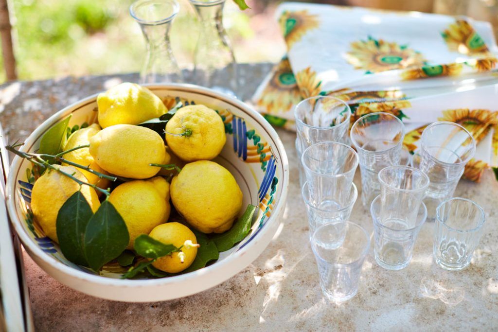 Bowl of lemons on an outdoor table ready to be made into lemonade