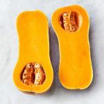 Butternut squash cut in half on a marble table