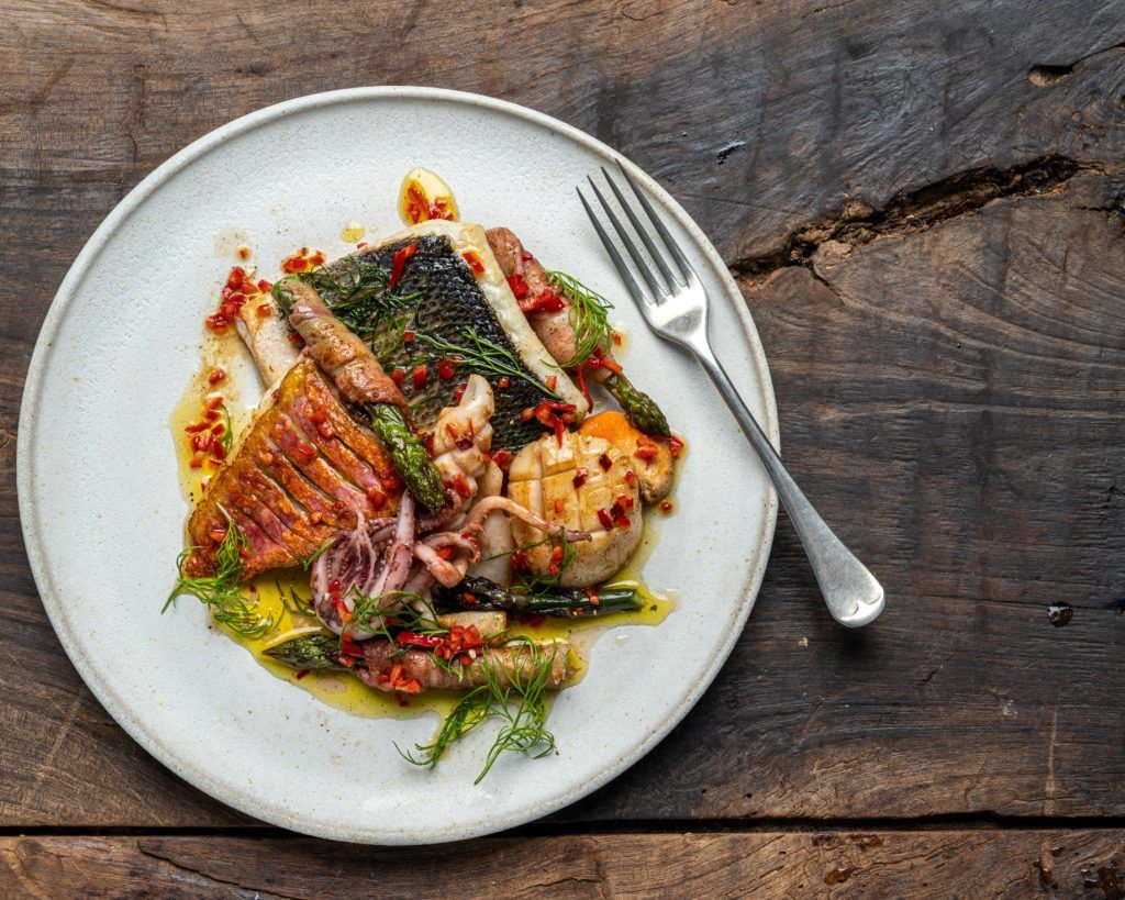 Crispy fish with seafood, asparagus and fennel tops – the perfect May recipe