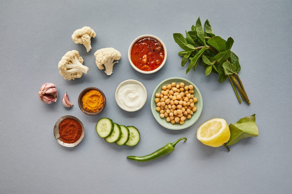 Ingredients laid out on a table including cauliflower, lemon, chickpeas and chilli