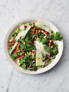 A vibrant plate full of broad beans, red pepper, almonds, parsley and shavings of Manchego cheese