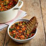 Bowl of hearty veg soup with toasted bread and a batch on the side as a cheap lunch idea