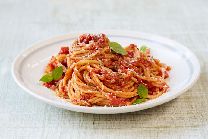 Bowl of fresh tomato spaghetti with basil leaves