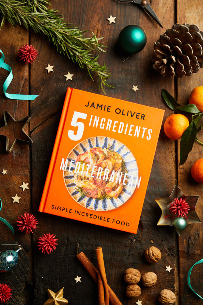 5 Ingredients Mediterranean book surrounded by pinecones and Christmas decorations