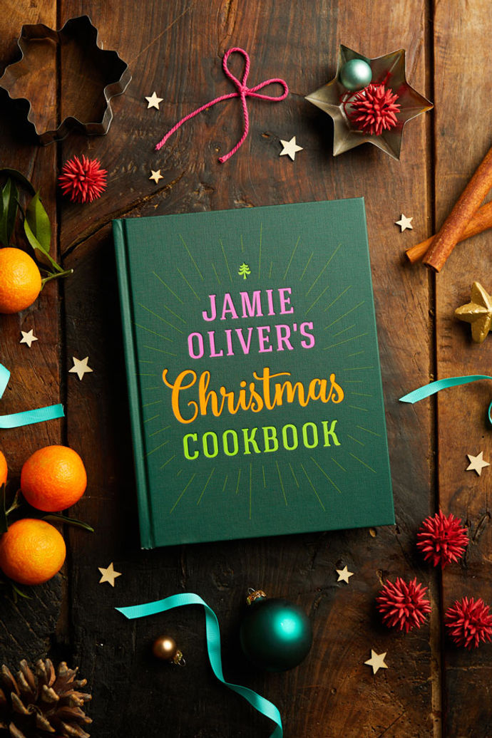 Jamie's Christmas Cookbook flatlay with tangerines, ribbons and festive decorations
