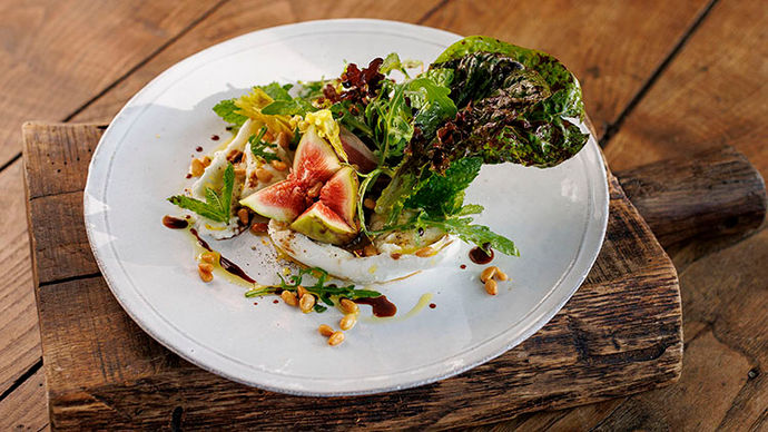 Plate of green salad with fig and balsamic