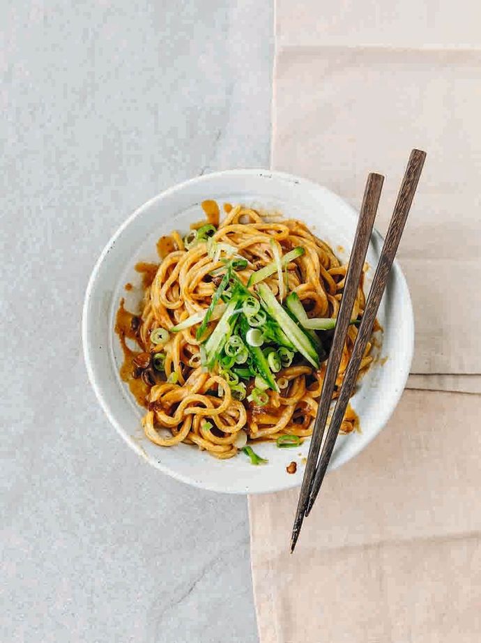 Sichuan-style sesame noodles in a bowl with a pair of chopsticks