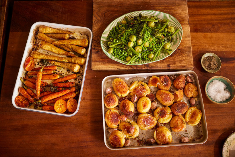 Roast potatoes, roast parsnips & carrots and a platter of Brussels sprouts ready to be served for Christmas