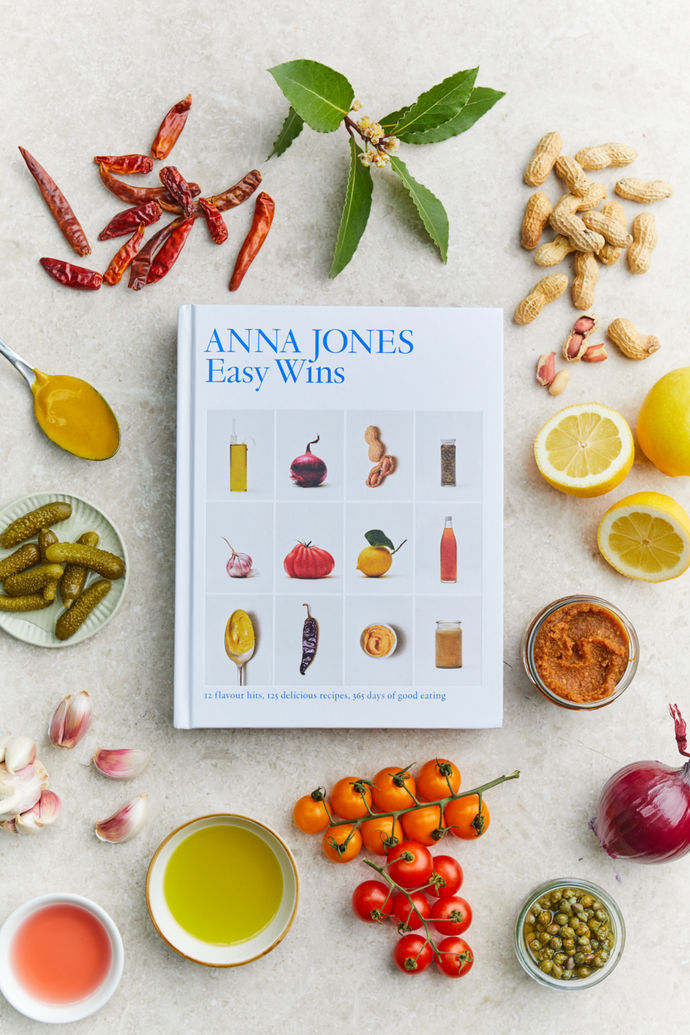 Cookbook by Anna Jones, titled 'Easy Wins' the book is surrounded by various ingredients.
