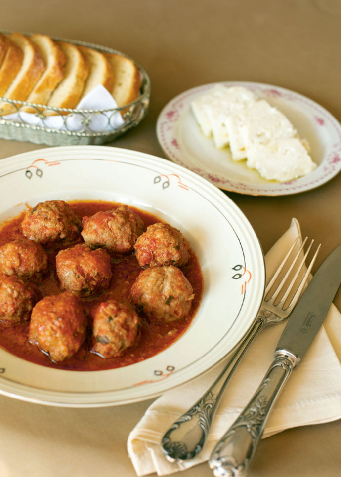 A plate of meatballs with cheese and bread above