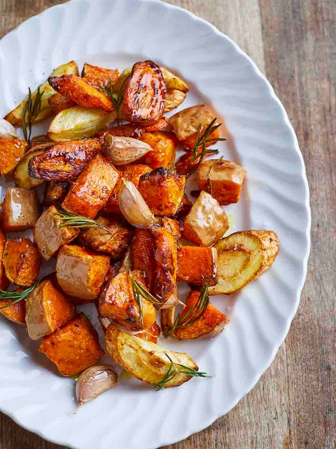 Air-fried, chopped carrots, parsnips and potatoes with rosemary on a white platter