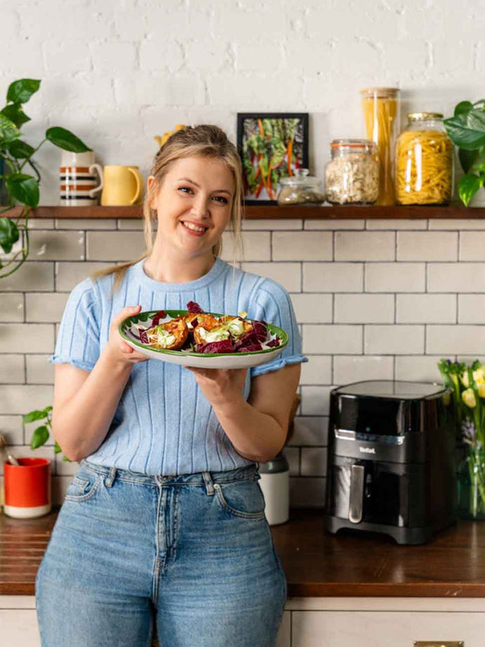 Poppy O'Toole holding a plate of her baked potato skins made in an air fryer