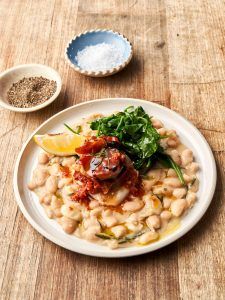 Prosciutto baked fish with beans and lemon