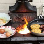 breakfast recipe - eggs, bacon and crumpets fried on a wooden fire