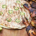 jalapeno flatbread with marinated, grilled chicken and lime slices on the side