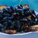 mussels cooked in herbs and toasted bread on the side