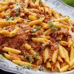 penne pasta with meat in tomato sauce and herbs