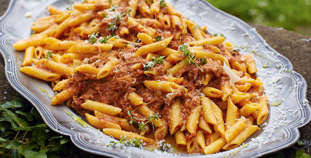 penne pasta with meat in tomato sauce and herbs