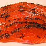 sliced raw salmon with seaweed and seeds on top