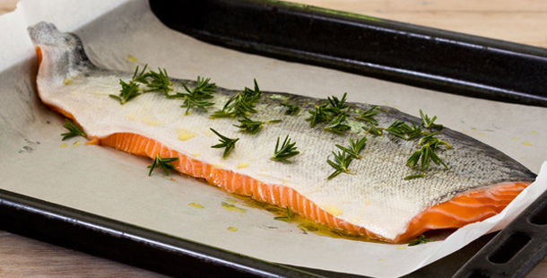 Salmon recipes - slice of raw salmon with herbs and oil on top