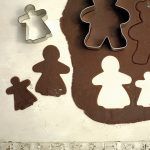 christmas gingerbread being cut out of dough