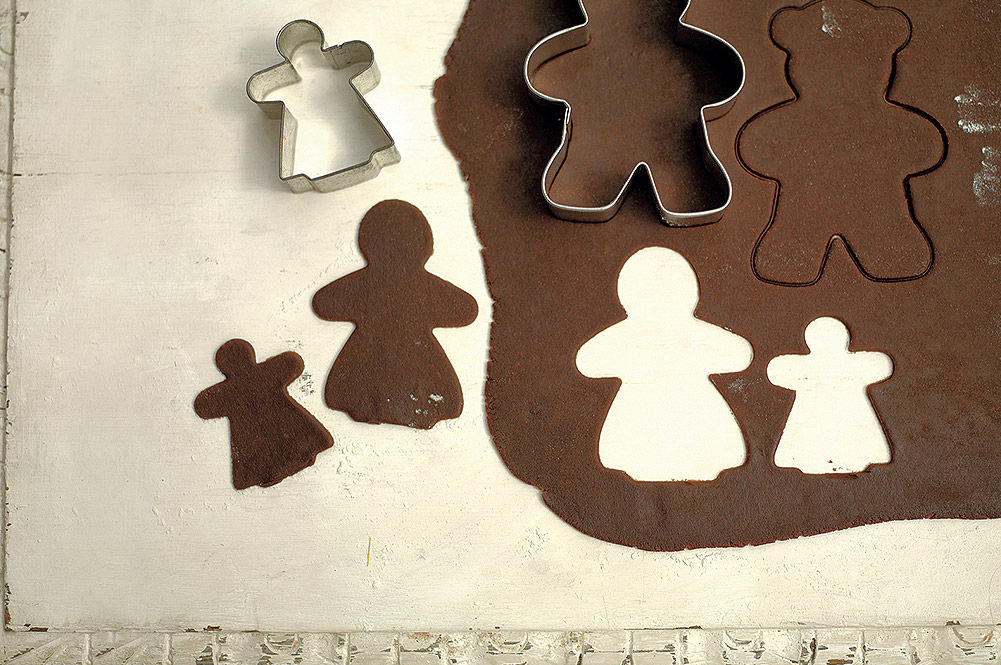 christmas gingerbread being cut out of dough