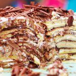 pancake cake with chocolate shavings on top and icing sugar