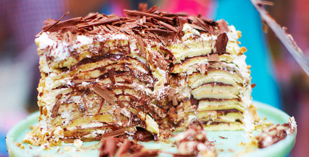 pancake cake with chocolate shavings on top and icing sugar