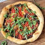 pizza recipe with tomato and herbs on top