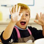 kid with flour on hand