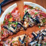 healthy pizza with ham and mushrooms on top