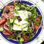 greek cheese with salad and herbs on top with olives