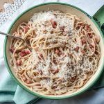 spaghetti carbonara with bacon and parmesan shavings on top