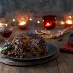 christmas pudding with drinks and candles around