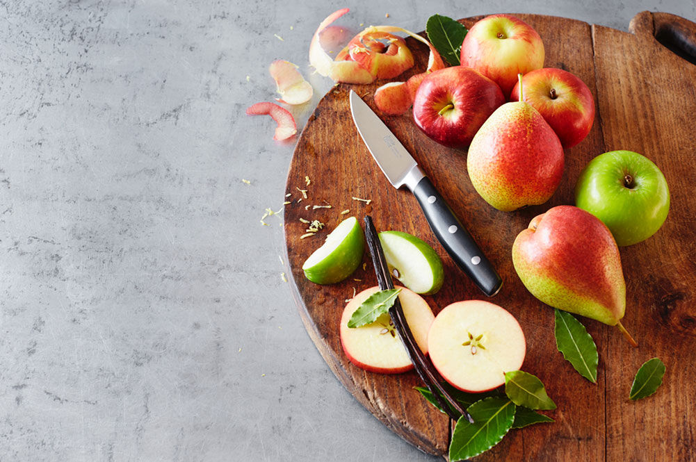 apples and pears being sliced on a chopping board