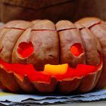 carve a pumpkin with candle in mouth