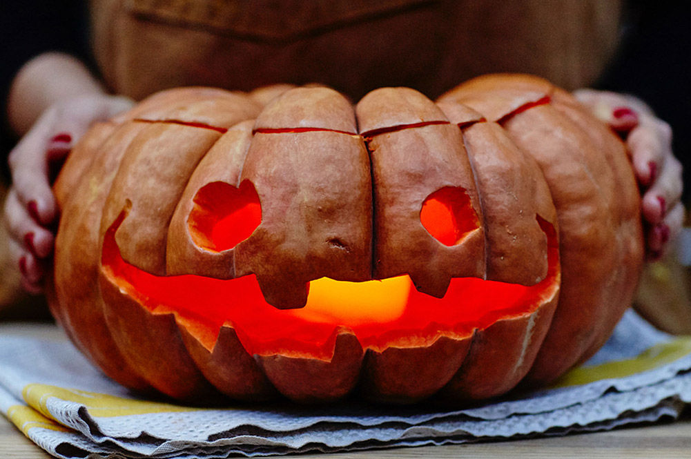 carve a pumpkin with candle in mouth