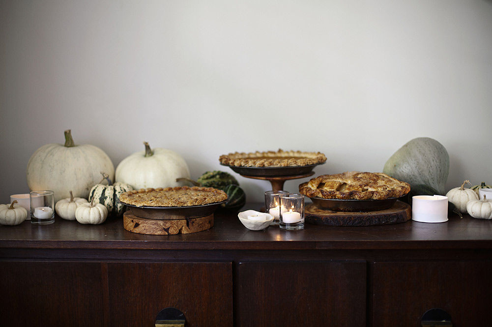 thanksgiving display with pies surrounded by pumpkins and squash