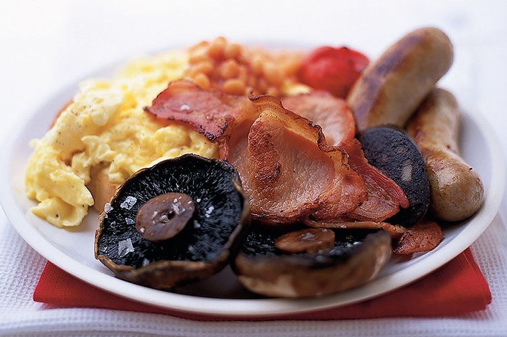 full english breakfast on a plate with scrambled eggs